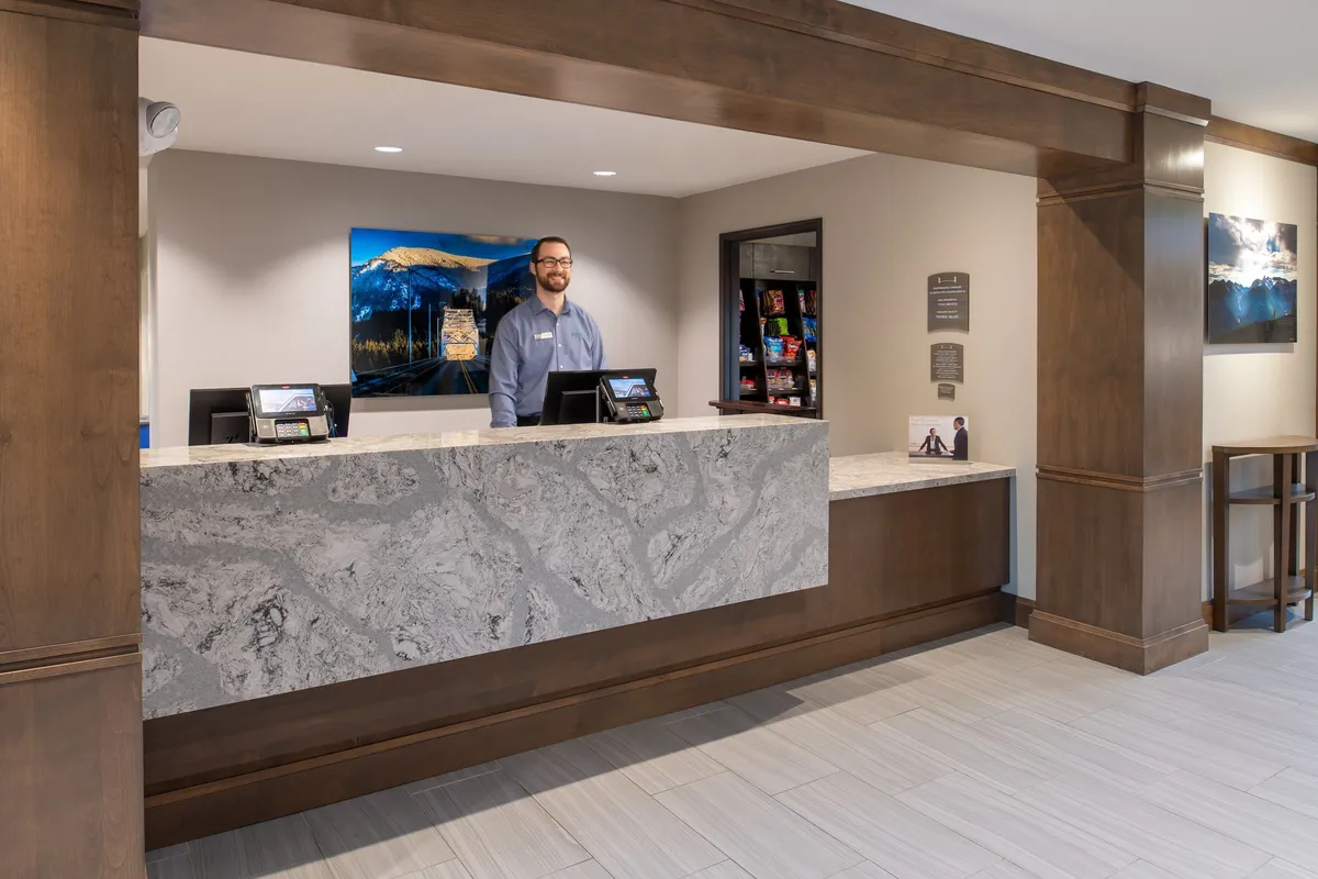 The interior reception area, featuring a friendly staff member at the desk and vibrant local artwork on the wall. This welcoming space sets the tone for guest service and easy access to amenities like parking and shared spaces.